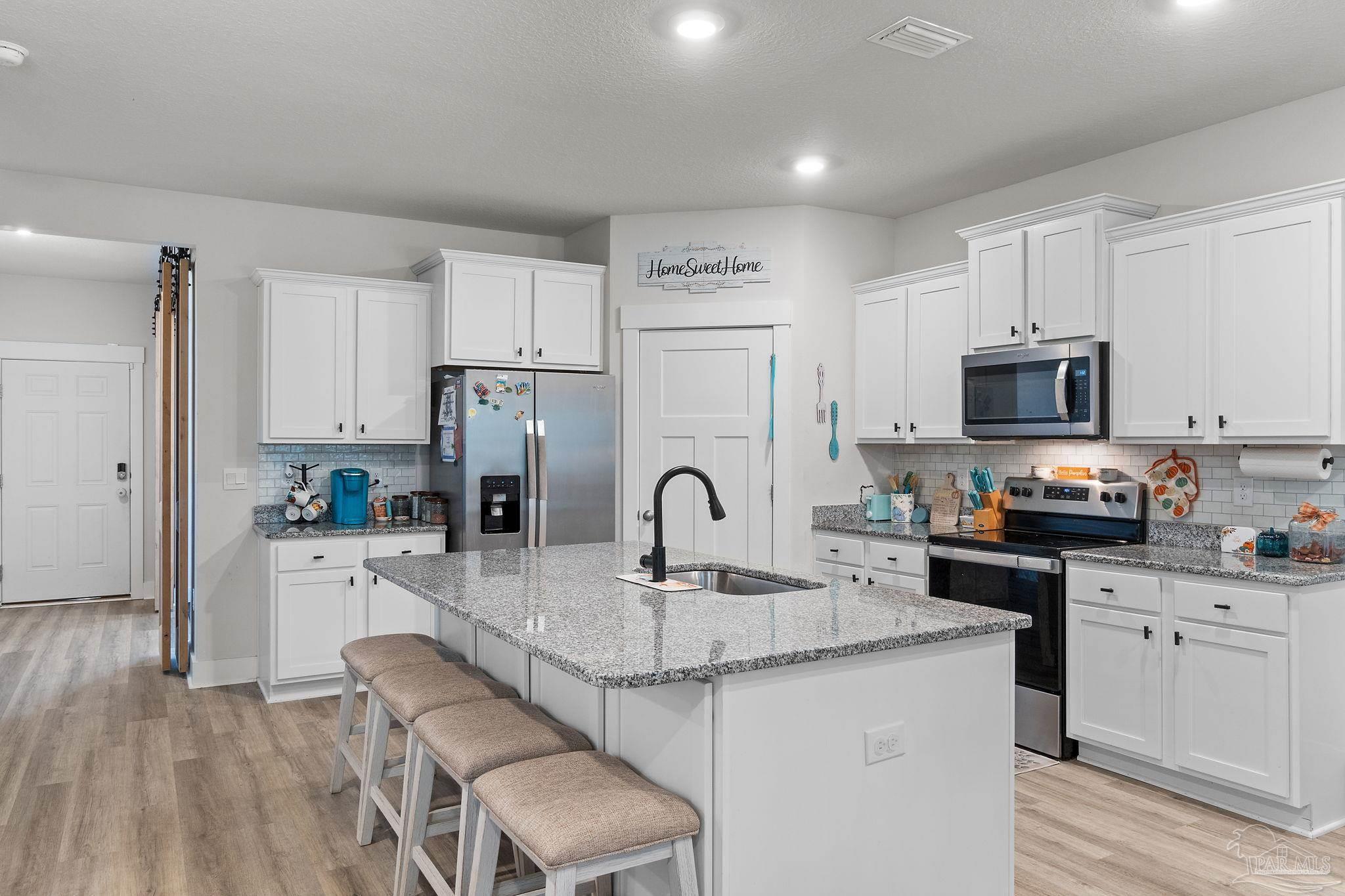 6060 Rutherford Loop Pensacola, FL 32526 - Photo 7 of 44 a kitchen with granite countertop a sink cabinets a refrigerator and a stove