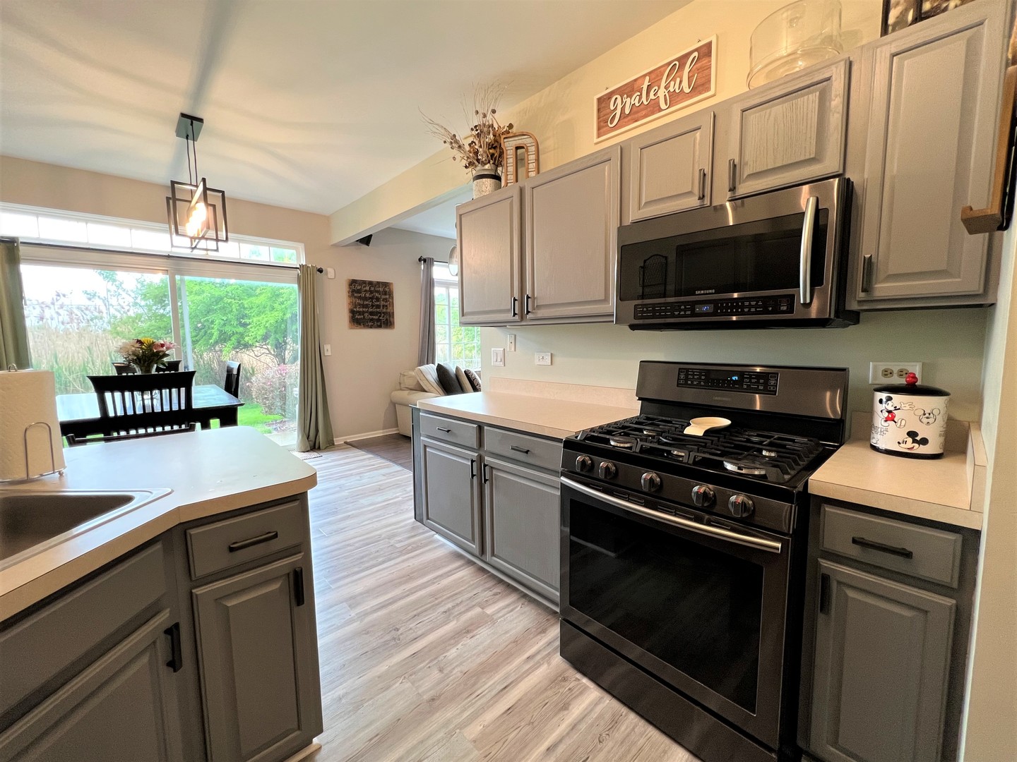 8563 Scheer Drive, Unit 8563 Tinley Park, IL 60487 - Photo 11 of 30 a kitchen with stainless steel appliances a stove a microwave a sink and cabinets