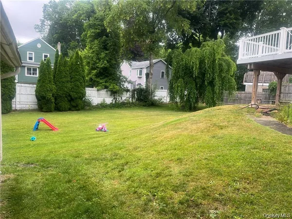 a view of a green yard with large trees
