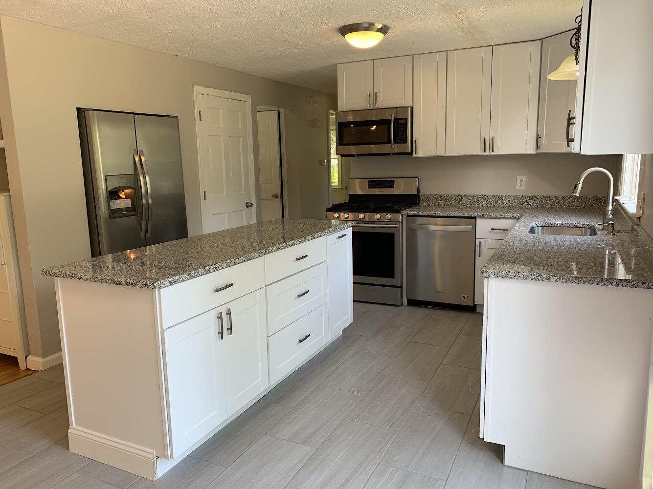 413 County Road Pocasset, MA 02559 - Photo 3 of 21 a kitchen with granite countertop white cabinets and stainless steel appliances