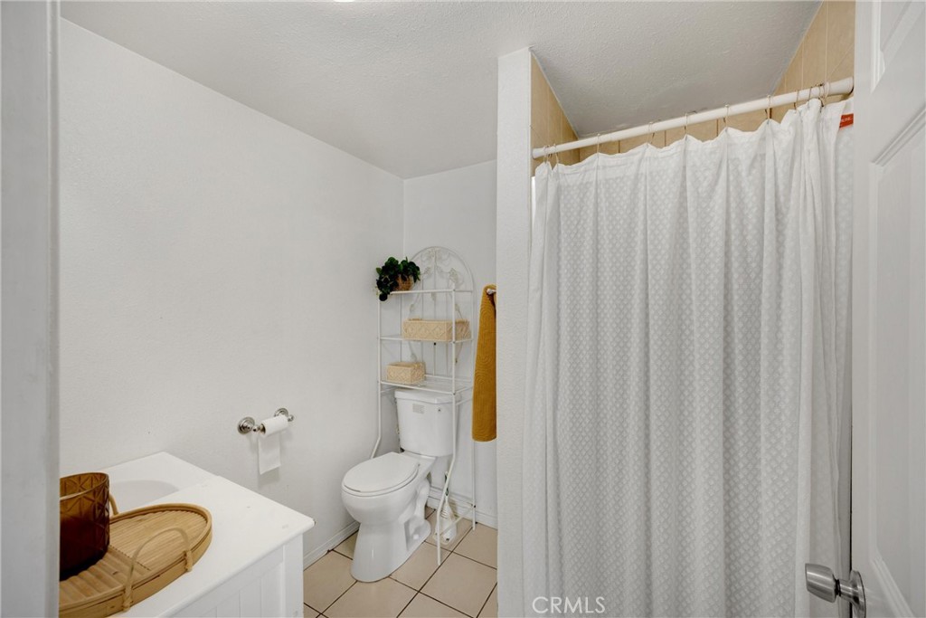 1003 West Stevenson Street Colton, CA 92324 - Photo 11 of 27 a white toilet sitting next to a shower curtain