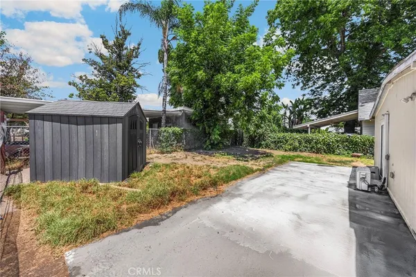 a view of backyard with small cabin and wooden fence