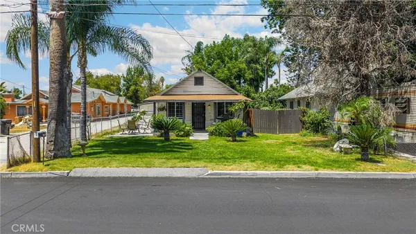 a view of a house with a yard and palm trees