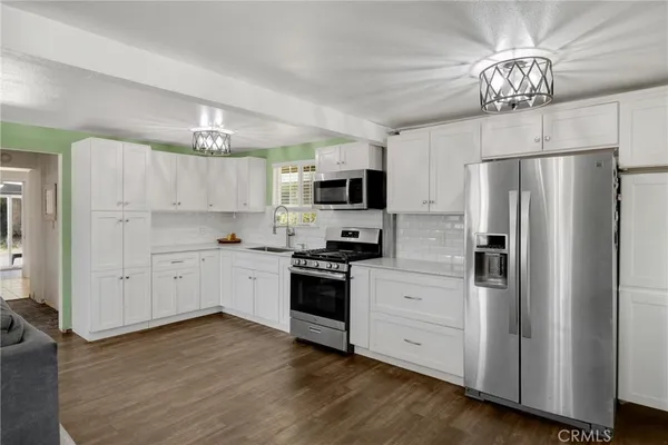 a kitchen with stainless steel appliances a refrigerator sink and microwave