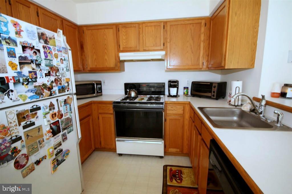 228 Schooner Road Manahawkin, NJ 08050 - Photo 8 of 19 a kitchen with stainless steel appliances granite countertop a stove a sink and a microwave