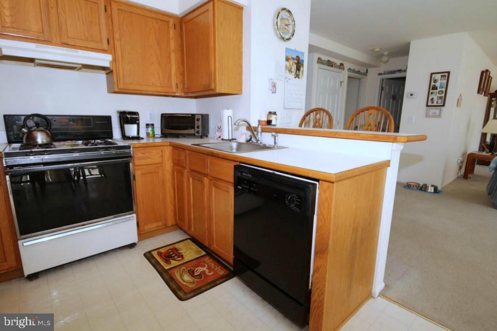 228 Schooner Road Manahawkin, NJ 08050 - Photo 9 of 19 a kitchen with stainless steel appliances granite countertop a stove a sink and a microwave
