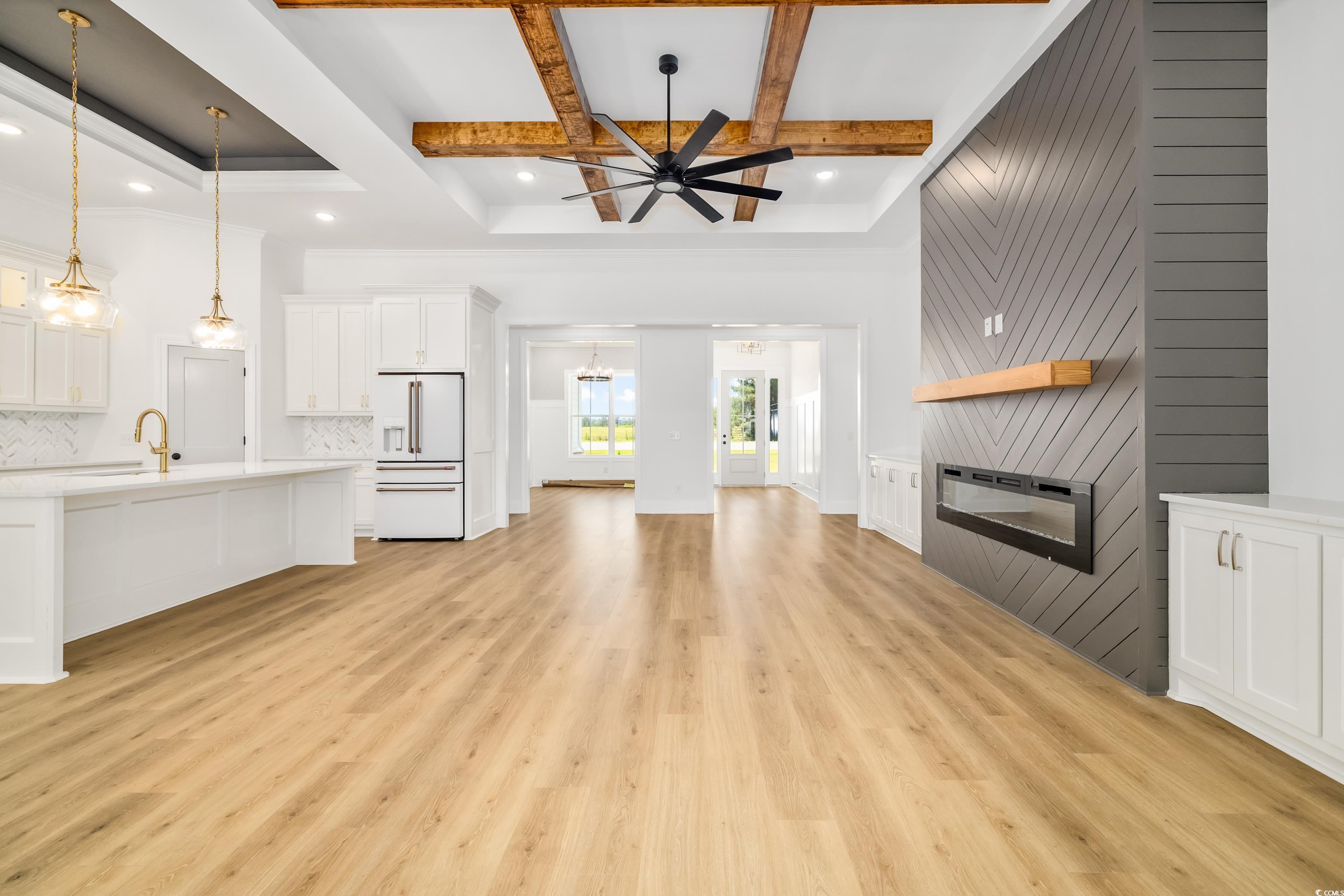 346 Ridge Road Galivants Ferry, SC 29544 - Photo 17 of 24 Unfurnished living room with a large fireplace, coffered ceiling, beam ceiling, light wood-style floors, and ceiling fan