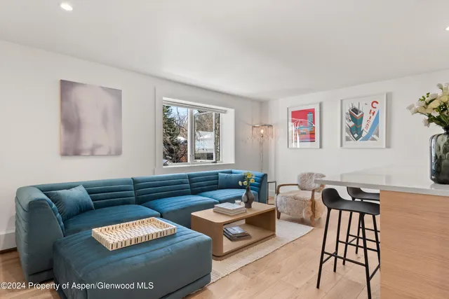 a living room with furniture a couch and paintings on the wall