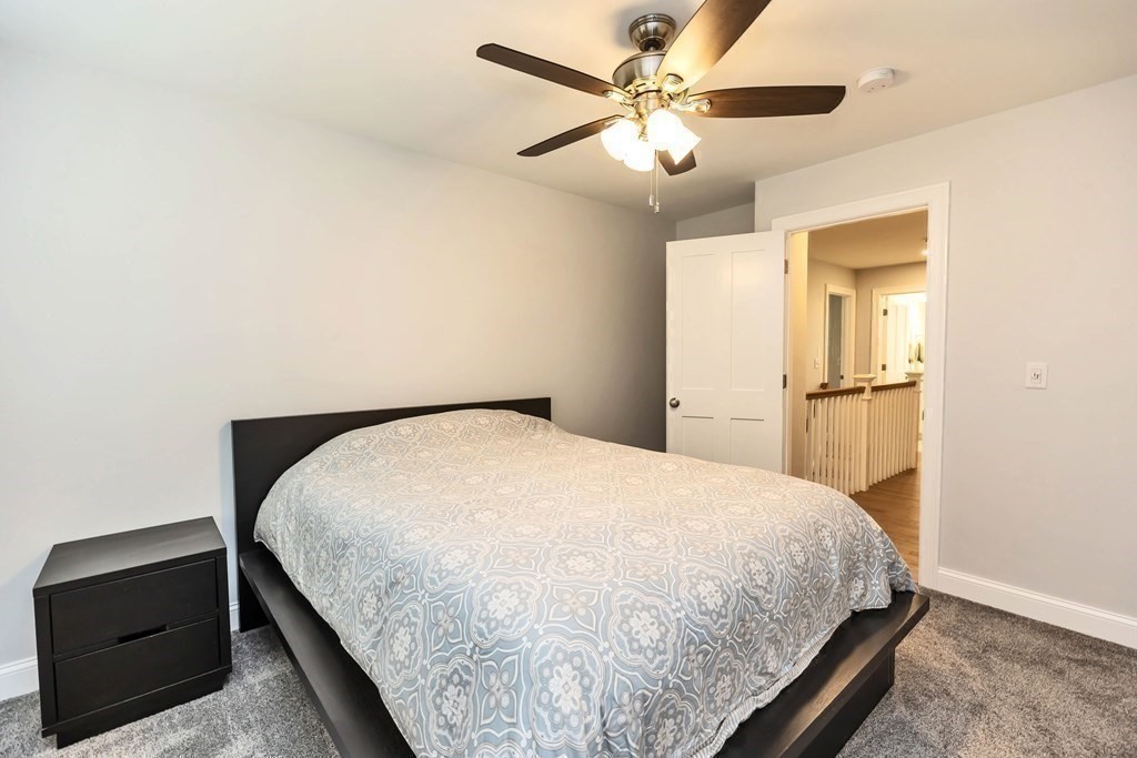 95-1 Lowell Road, Unit 1 Pepperell, MA 01463 - Photo 27 of 36 a bedroom with a large bed and a chandelier