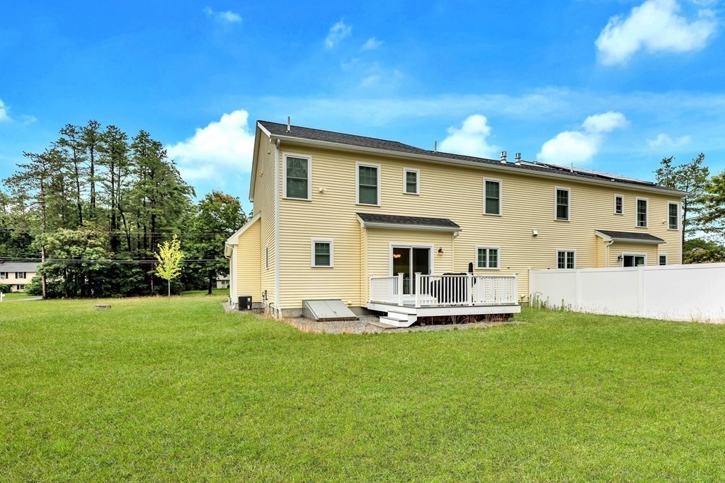 95-1 Lowell Road, Unit 1 Pepperell, MA 01463 - Photo 33 of 36 a front view of a house with a yard patio and fire pit
