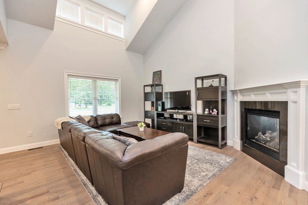 95-1 Lowell Road, Unit 1 Pepperell, MA 01463 - Photo 8 of 36 a living room with furniture a fireplace and a flat screen tv