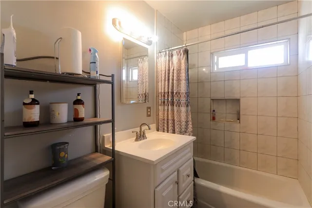 a bathroom with a bathtub sink and mirror