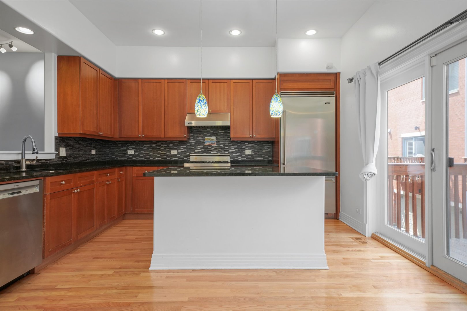 1055 West Monroe Street, Unit A Chicago, IL 60607 - Photo 4 of 28 a large kitchen with stainless steel appliances granite countertop wooden cabinets a oven and a large island