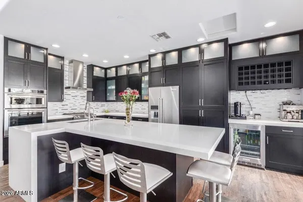 a kitchen with kitchen island a refrigerator and a stove