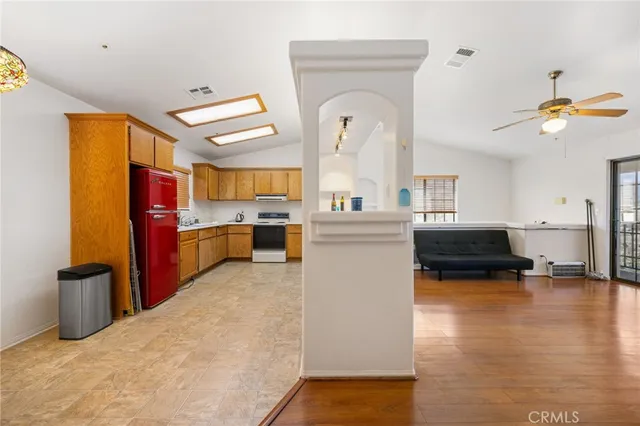 a living room with stainless steel appliances furniture and a kitchen view