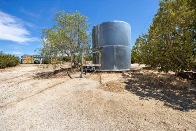 a view of a dry yard with wooden fence