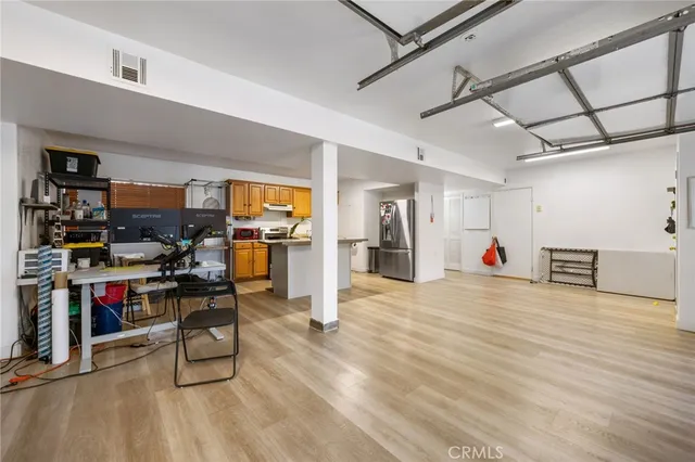 a living room with lots of wooden furniture and a view of kitchen