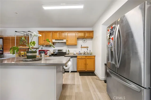 a kitchen with stainless steel appliances a refrigerator and a stove top oven
