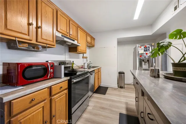 a kitchen with stainless steel appliances granite countertop a stove a sink and a microwave