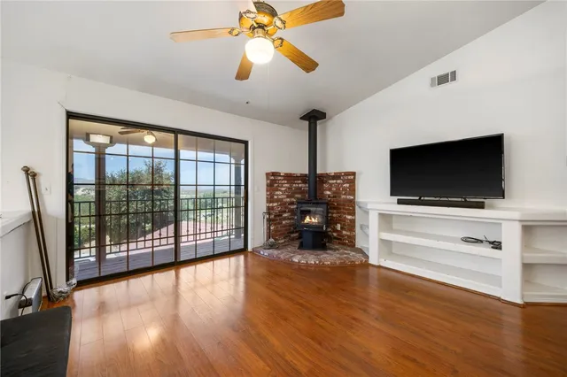 a view of a livingroom with furniture flat screen tv wooden floor and a chandelier fan