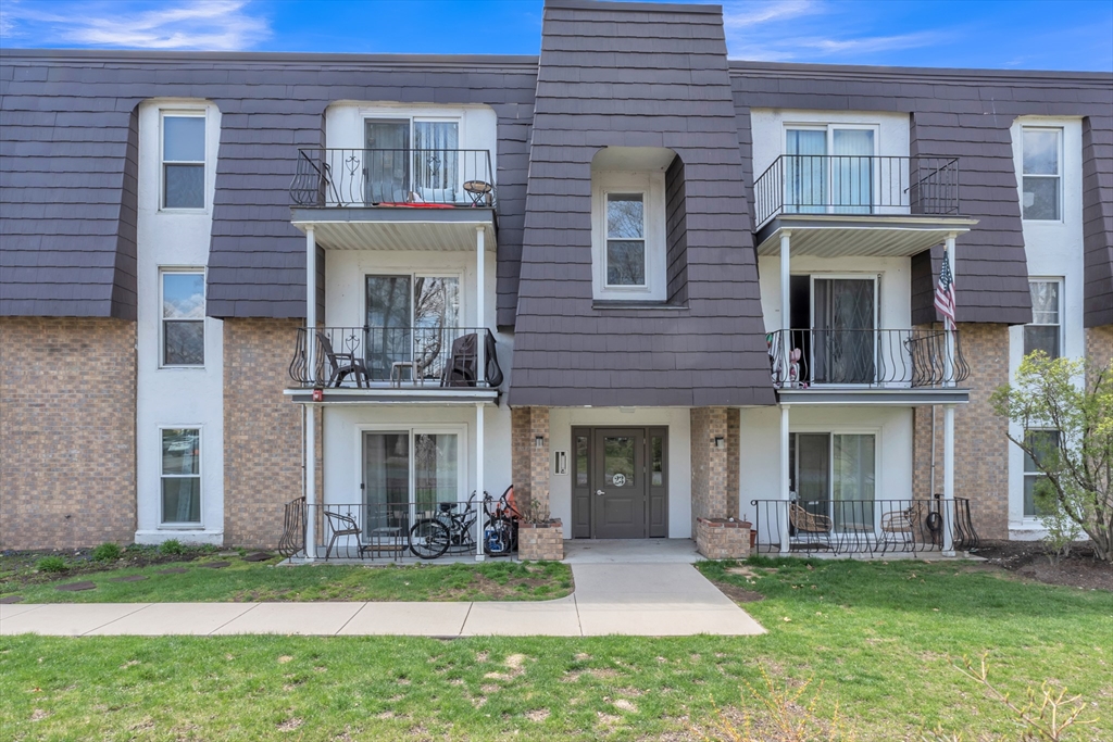 front view of a brick house with a yard