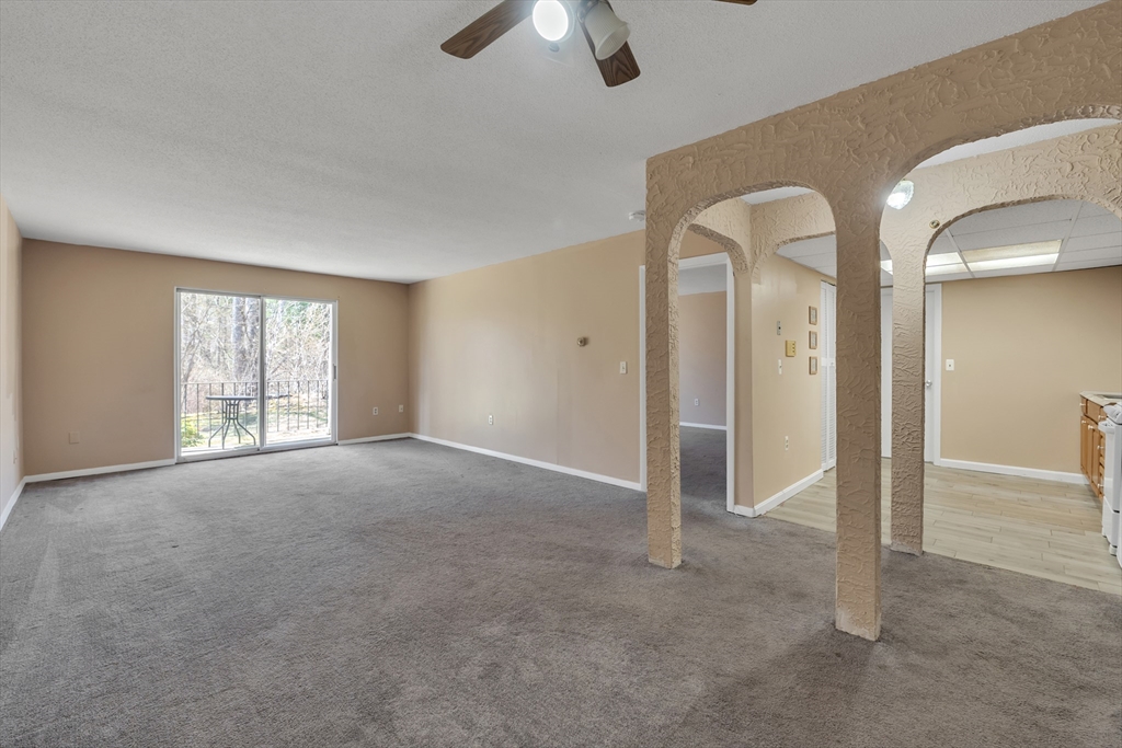 23 Shadowbrook Lane, Unit 6 Milford, MA 01757 - Photo 2 of 11 an empty room with chandelier fan and windows