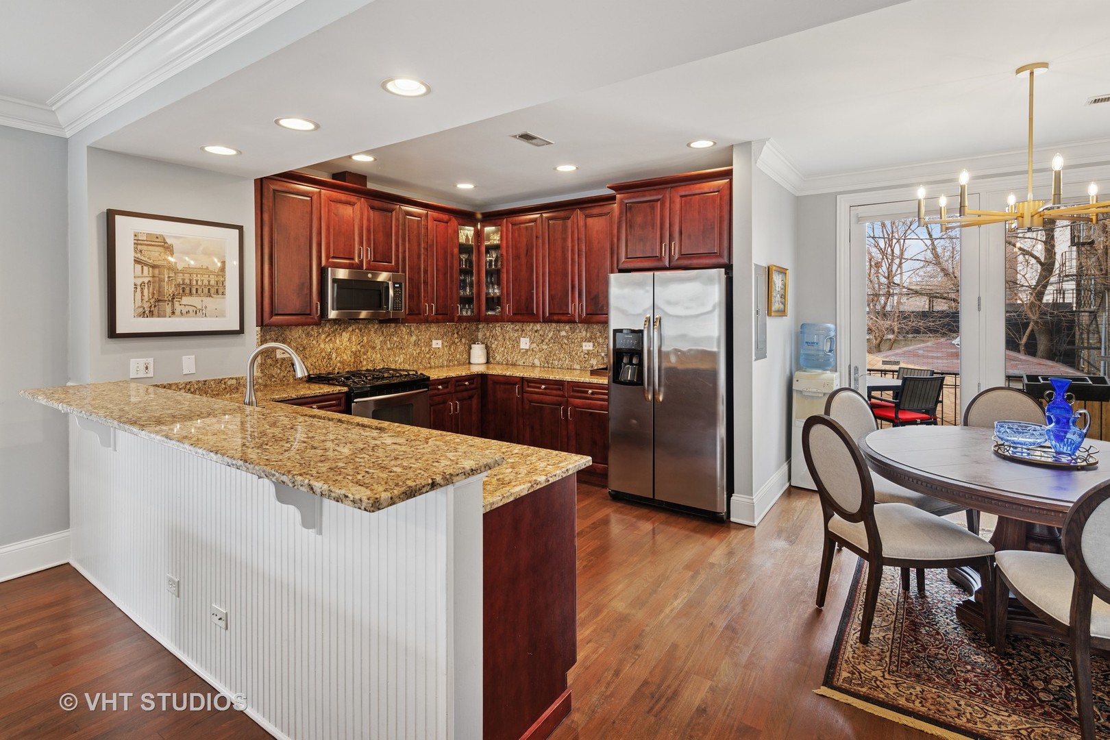 1608 West Grace Street Chicago, IL 60613 - Photo 5 of 25 a kitchen with stainless steel appliances granite countertop a refrigerator a sink a stove a dining table and chairs with wooden floor