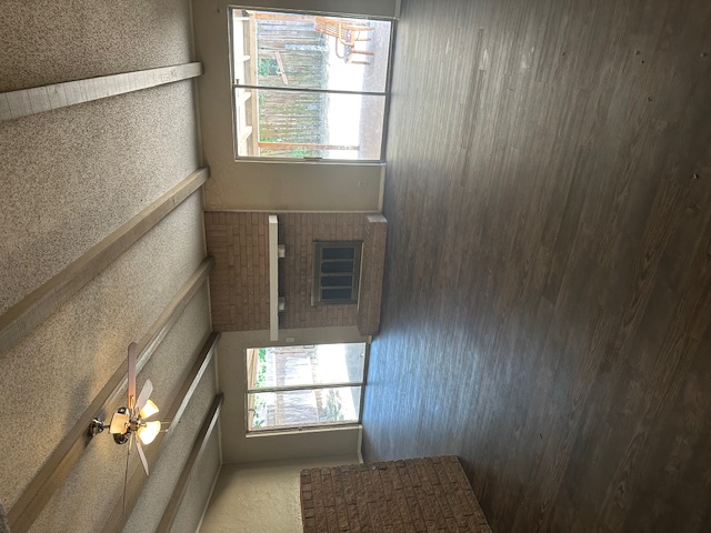 1001 Ridgeline Drive Round Rock, TX 78664 - Photo 2 of 11 Unfurnished living room featuring a fireplace, a textured ceiling, dark wood-type flooring, beam ceiling, and ceiling fan