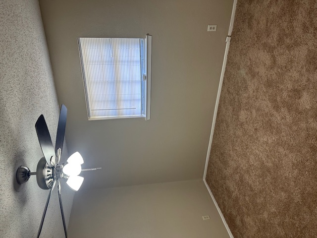 1001 Ridgeline Drive Round Rock, TX 78664 - Photo 9 of 11 Unfurnished room with a textured ceiling, carpet, and a ceiling fan