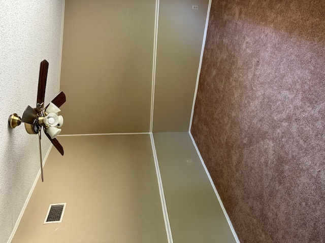 1001 Ridgeline Drive Round Rock, TX 78664 - Photo 10 of 11 Spare room featuring dark colored carpet, a textured ceiling, a ceiling fan, and crown molding