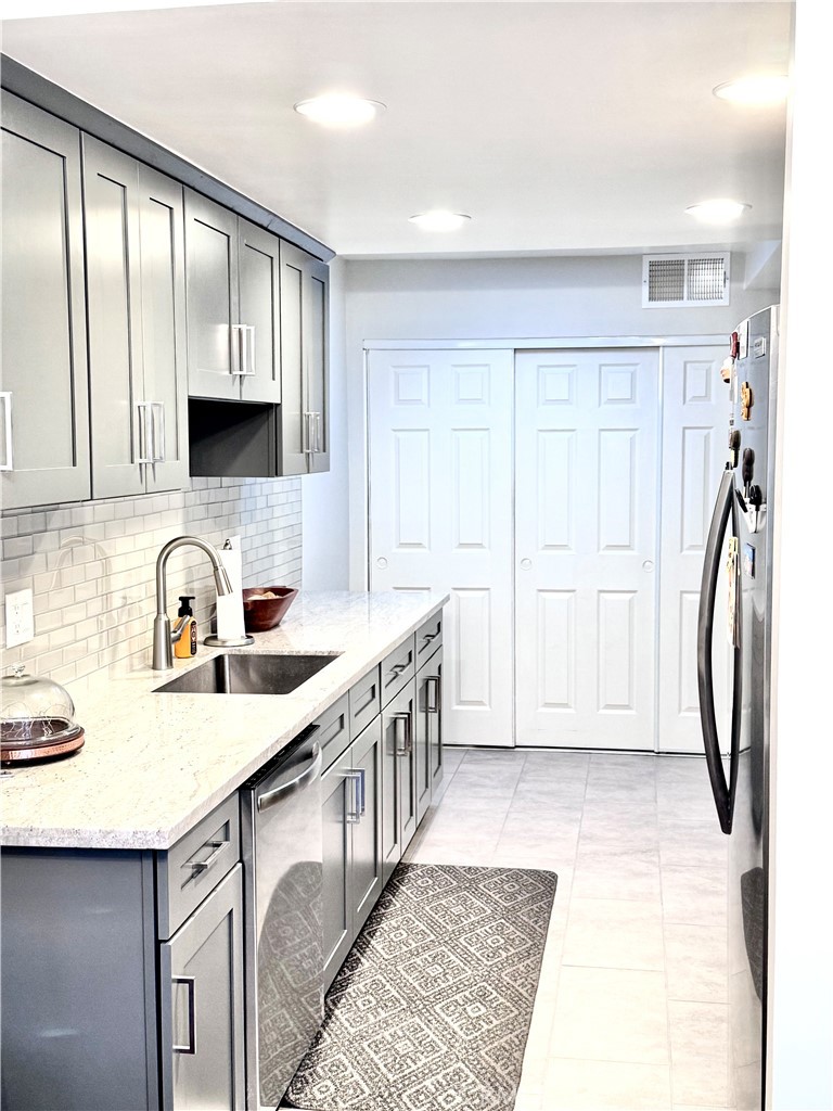 16255 Devonshire Street, Unit 7 Granada Hills, CA 91344 - Photo 6 of 16 a kitchen with stainless steel appliances granite countertop a sink a stove a refrigerator and cabinets
