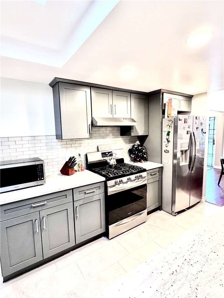 16255 Devonshire Street, Unit 7 Granada Hills, CA 91344 - Photo 7 of 16 a kitchen with stainless steel appliances granite countertop a stove a sink and a refrigerator
