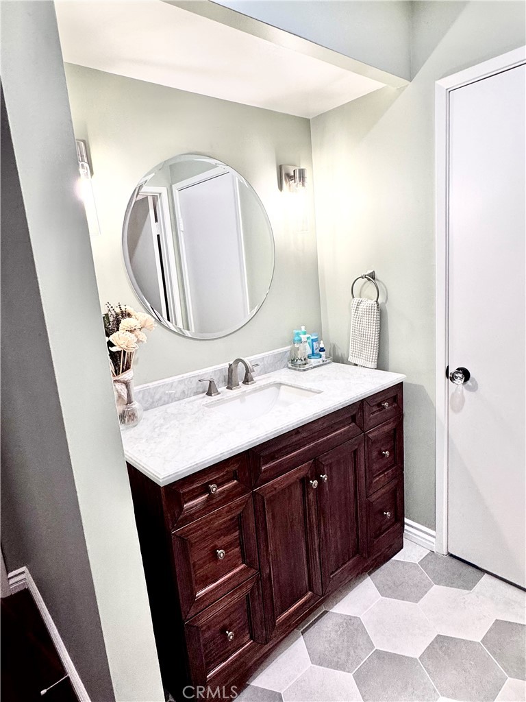 16255 Devonshire Street, Unit 7 Granada Hills, CA 91344 - Photo 10 of 16 a bathroom with a double vanity sink and a mirror