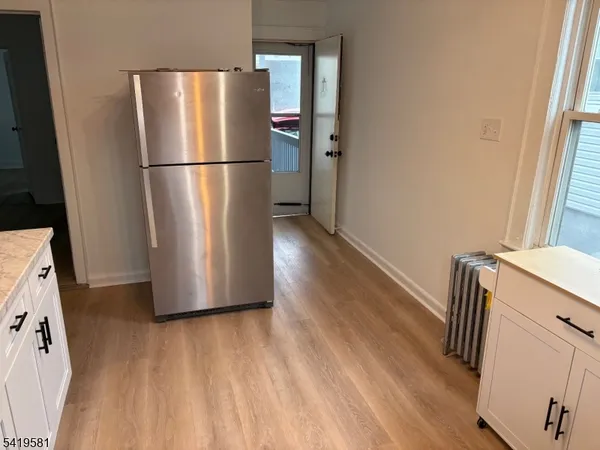 a view of a kitchen with wooden floor and a hallway