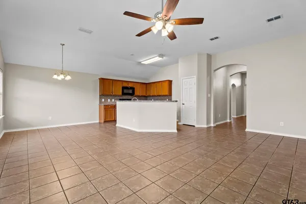 a view of a big room with wooden floor and a ceiling fan
