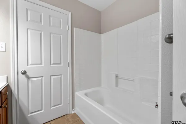 a white bath tub sitting next to a white cabinet