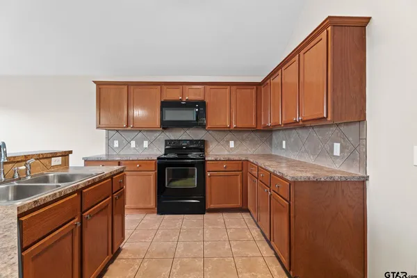a kitchen with stainless steel appliances granite countertop a sink stove and cabinets