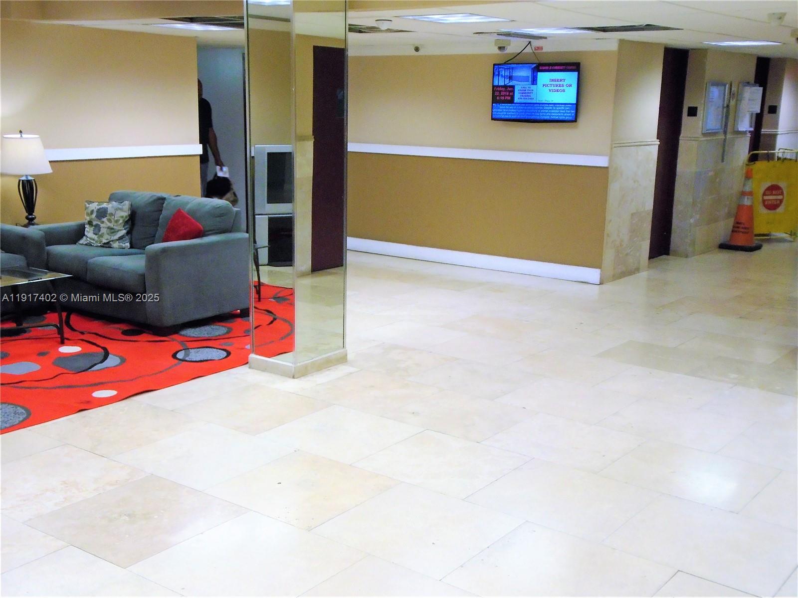 4174 Inverrary Drive, Unit 1004 Lauderhill, FL 33319 - Photo 1 of 53 a living room with furniture and a flat screen tv