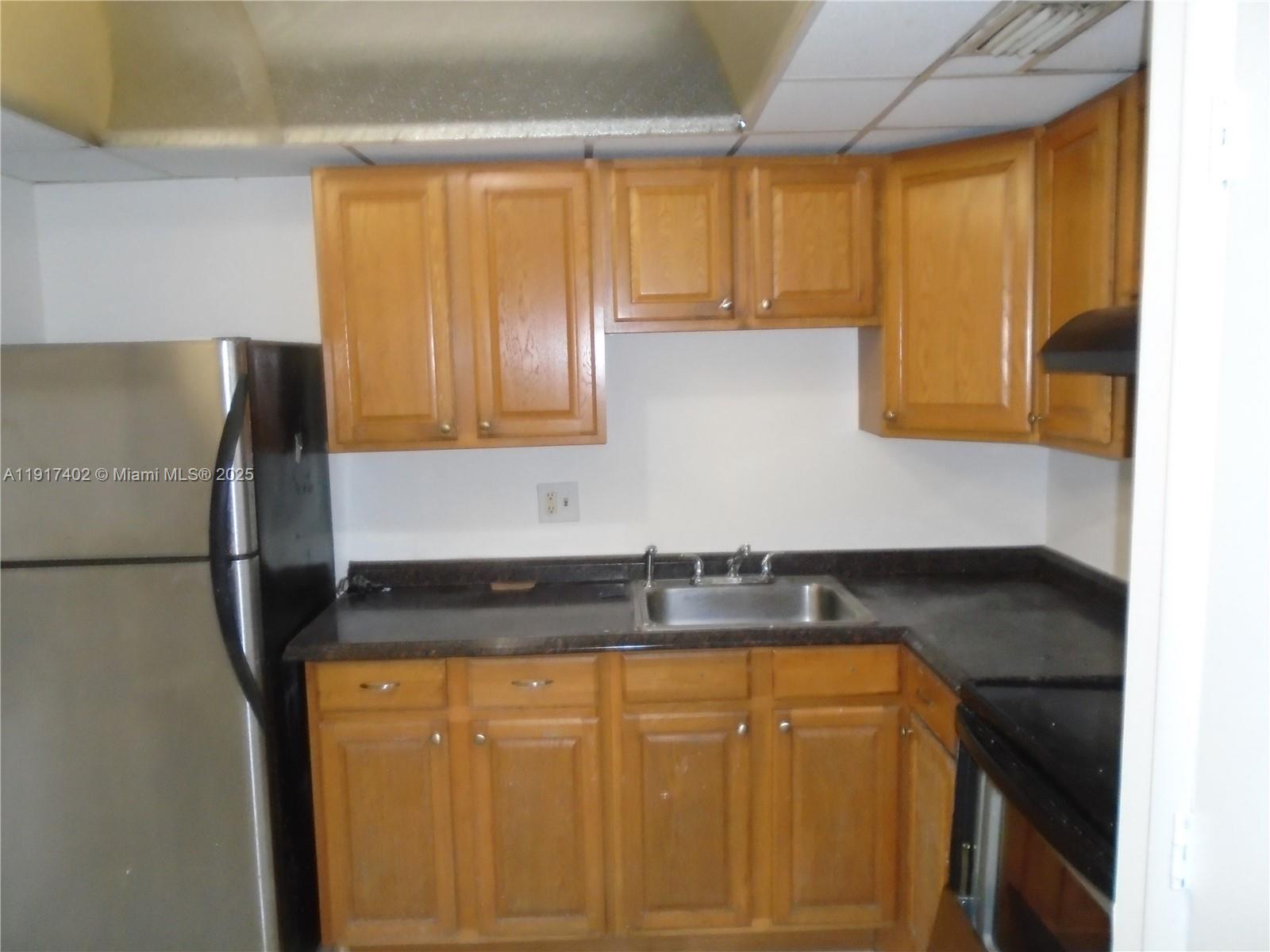 4174 Inverrary Drive, Unit 1004 Lauderhill, FL 33319 - Photo 26 of 53 a kitchen with granite countertop cabinets and refrigerator