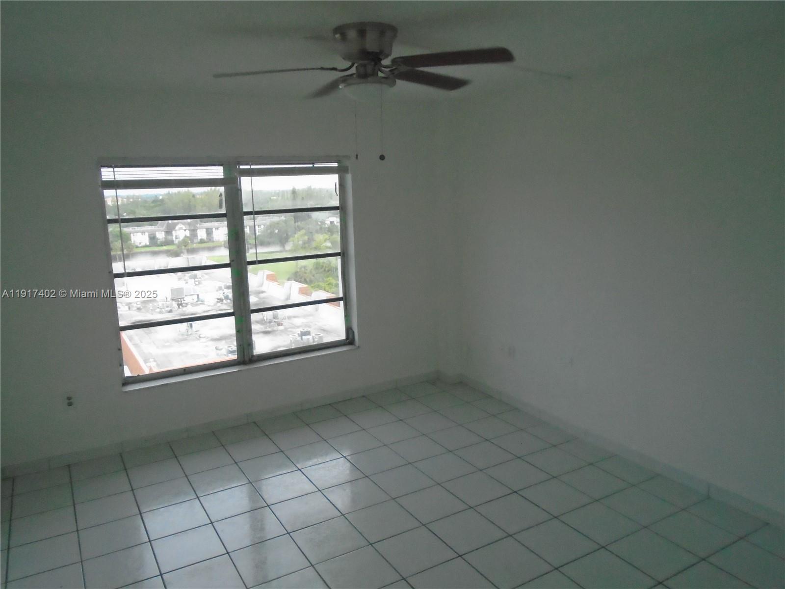 4174 Inverrary Drive, Unit 1004 Lauderhill, FL 33319 - Photo 31 of 53 an empty room with chandelier fan and window