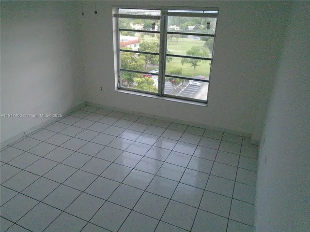 an empty room with wooden floor and a window