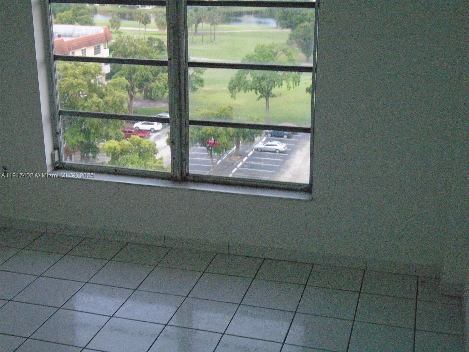 4174 Inverrary Drive, Unit 1004 Lauderhill, FL 33319 - Photo 34 of 53 an empty room with wooden floor and a window