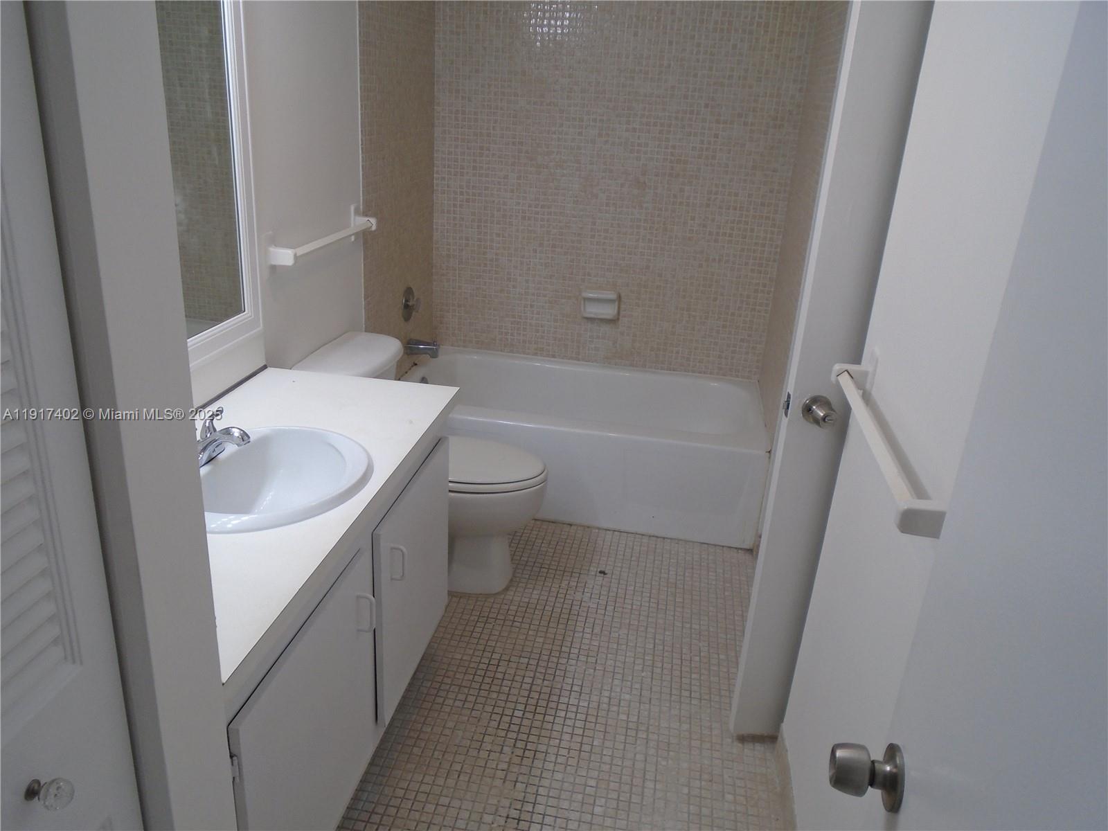 4174 Inverrary Drive, Unit 1004 Lauderhill, FL 33319 - Photo 6 of 53 a bathroom with a sink a toilet and shower