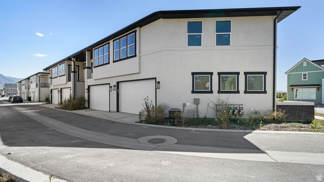 729 South Harrison Drive West Springville, UT 84663 - Photo 21 of 36 Contemporary townhome exterior featuring light-toned stucco siding and contrasting dark trim