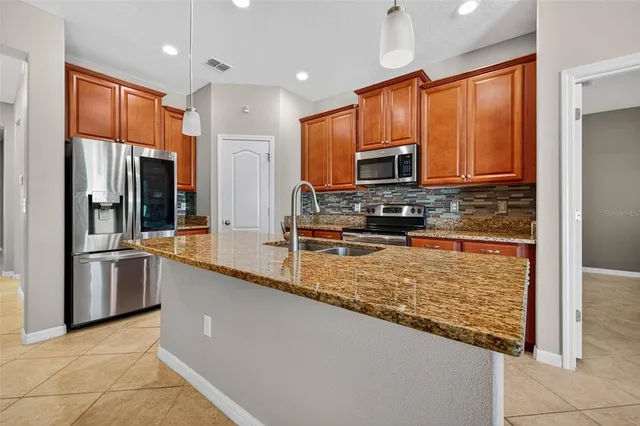 a kitchen with stainless steel appliances granite countertop a refrigerator a stove top oven a sink and dishwasher