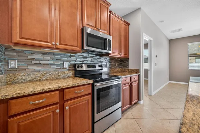 a kitchen with stainless steel appliances granite countertop a sink stove and microwave