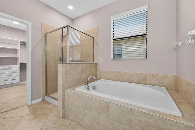 a white bath tub sitting in a bathroom next to a window
