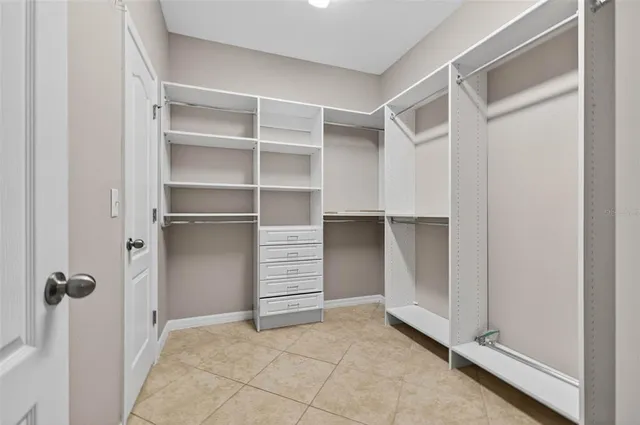 a view of walk in closet with empty racks