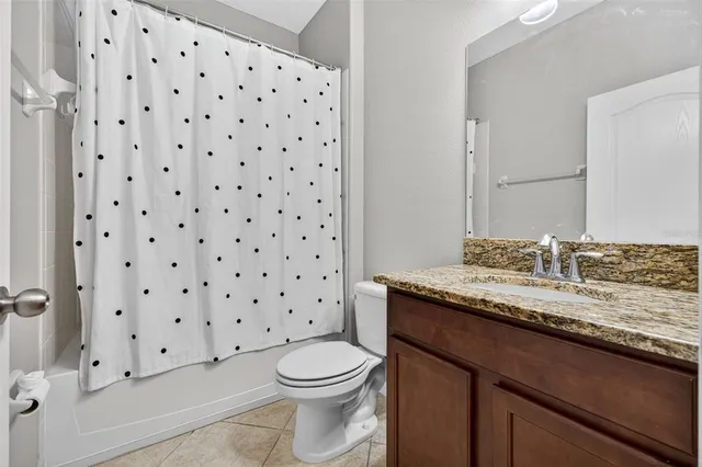 a bathroom with a granite countertop toilet a sink and a mirror