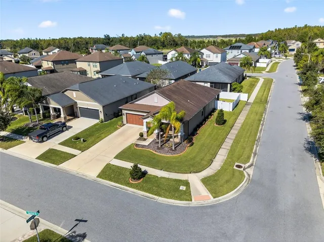 an aerial view of residential houses with outdoor space and parking